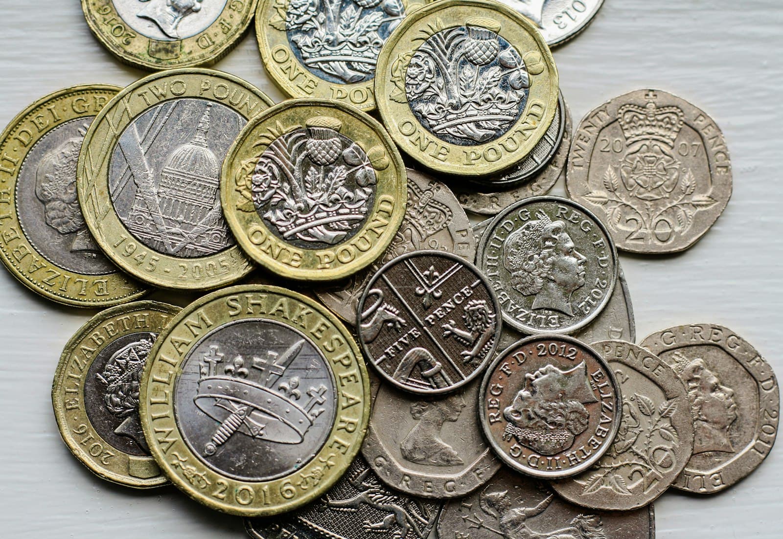 A pile of British pound coins and small change on a table